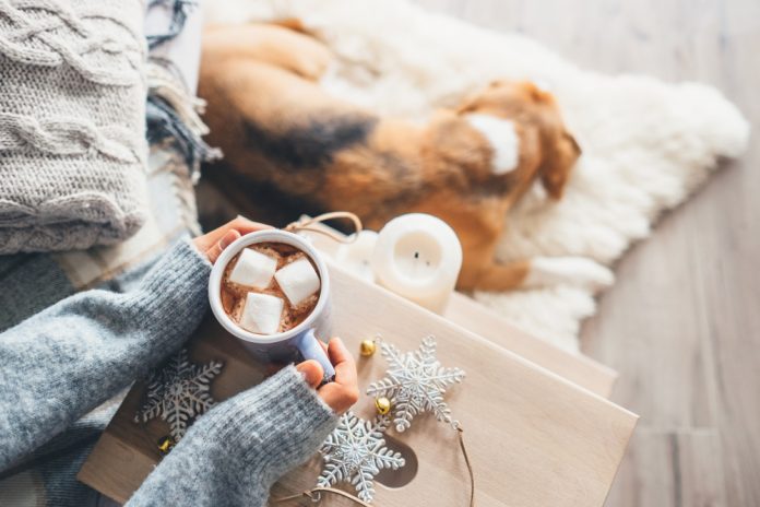 drinking hot chocolate with dog at feet